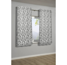 Dva vzorované závěsy visí před oknem