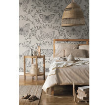 Ložnice s postelí, nočním stolkem, lampou a tapetou s motýlím vzorem