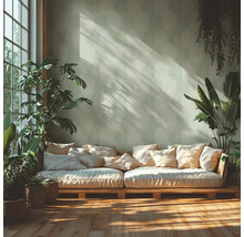 Světlá místnost s pohovkou z palet, polštáři a pokojovými rostlinami