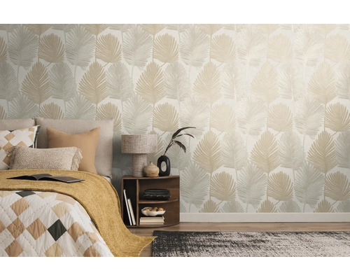 Ložnice s postelí a stěnou s tapetou s listy.
