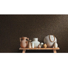 Různé vázy na stole před strukturovanou stěnou