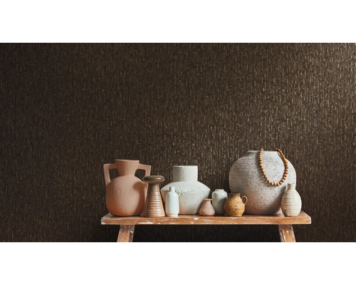 Různé vázy na stole před strukturovanou stěnou