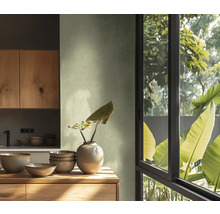 Světlá kuchyň s dřevěnými prvky, nádobím a oknem s výhledem do zeleně