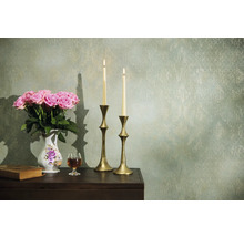 Dekorativní aranžmá s růžemi, svíčkami a starožitnými prvky na stole před vzorovanou zdí