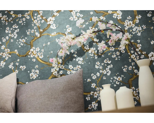 Detailní záběr stěny s květinovou tapetou, polštáři a dekorativními vázami.