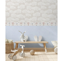 Dětský pokoj s tapetou s motivy mraků a dřevěnými hračkami