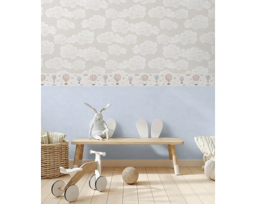 Dětský pokoj s tapetou s motivy mraků a dřevěnými hračkami