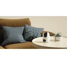 Kamera Imou na stole vedle pokojové rostliny a pohovky