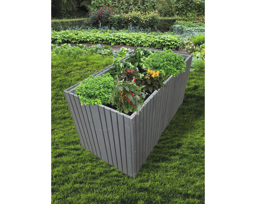 Dřevěný vyvýšený záhon s rostlinami na zahradě