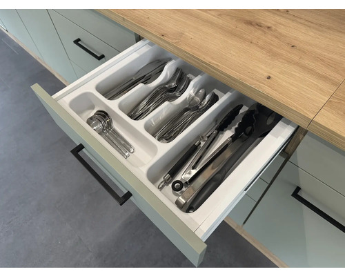 Otevřená kuchyňská zásuvka s vložkou na příbory a různými kusy příborů.