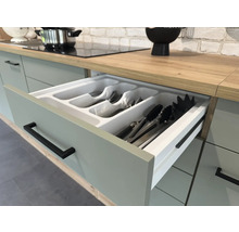 Kuchyňská zásuvka s vložkou na příbory ve světlé kuchyni.