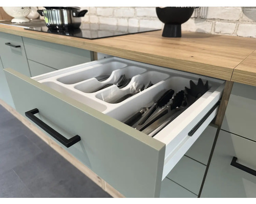 Kuchyňská zásuvka s vložkou na příbory ve světlé kuchyni.