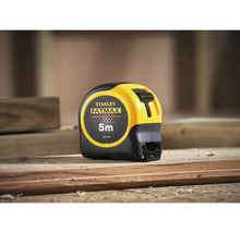 Svinovací metr Stanley Fatmax o délce 5 metrů na dřevěném trámu