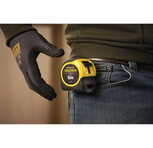 Svinovací metr Stanley Fatmax o délce pět metrů připevněný k pasu kalhot