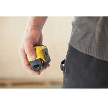 Ruka drží žlutý a černý svinovací metr.