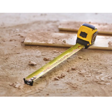 Žlutý svinovací metr na zemi