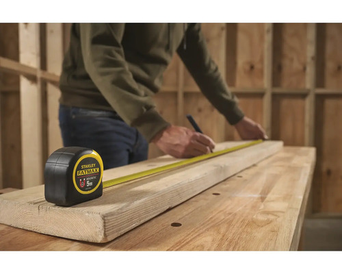 Svinovací metr Stanley Fatmax 5 metrů při měření dřevěné desky