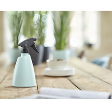 Plastová rozprašovací láhev s rozprašovací hlavicí na dřevěném stole