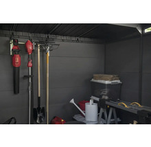 Vnitřek zahradního domku s zahradním nářadím, úložnými boxy a ponkem