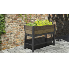 Vyvýšený záhon s úložným prostorem a rostlinami před cihlovou zdí