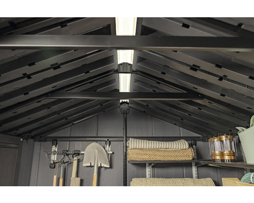 Vnitřní pohled na zahradní domek s policemi, nářadím a osvětlením