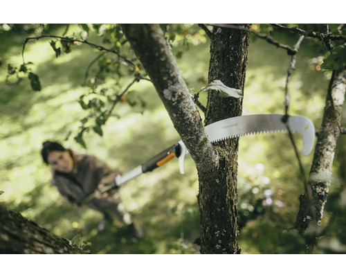 Žena řeže větev větvovou pilou