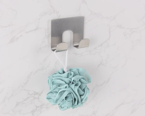 Sprchová houba visí na nerezovém nástěnném háku