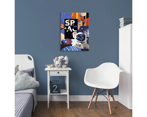 Dekorativní vesmírný motiv na modré stěně v dětském pokoji s postelí, stolem a židlí