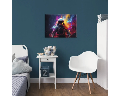 Dekorativní dětský pokoj s obrázkem astronauta na modré stěně nad nočním stolkem.