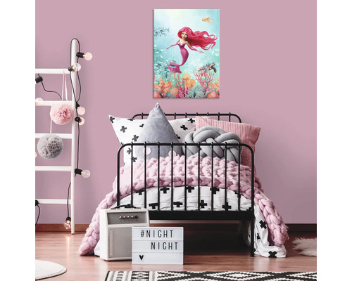 Dětský pokoj s plátnem mořské panny nad postelí.