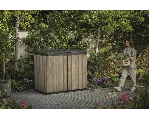 Zahradní skříň venku se ženou nesoucí rostliny