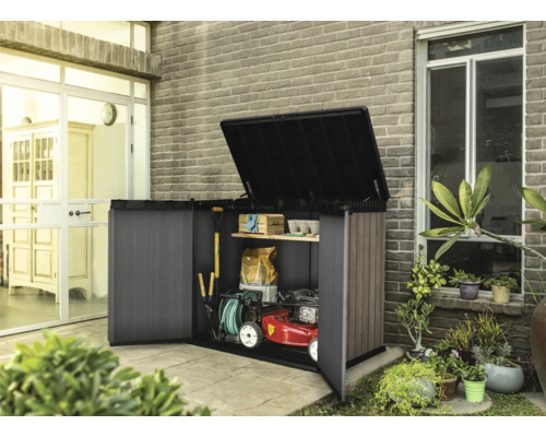 Otevřená skříň na nářadí se zahradním nářadím a sekačkou na trávu