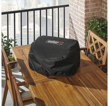Černý ochranný kryt na gril Weber na dřevěném stole