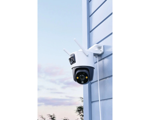 Venkovní bezpečnostní kamera se dvěma anténami namontovaná na stěně domu