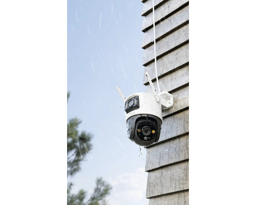 Venkovní bezpečnostní kamera na stěně domu v dešti