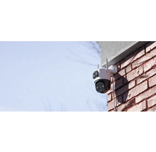 Venkovní bezpečnostní kamera namontovaná na cihlové zdi