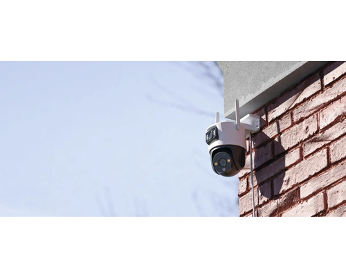 Venkovní bezpečnostní kamera namontovaná na cihlové zdi
