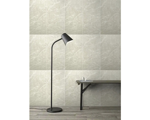 Pohled do místnosti s podlahovými a nástěnnými dlaždicemi se vzhledem mramoru, stojací lampou a lavicí