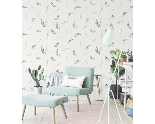 Světlá místnost s křeslem, stoličkou, stojací lampou a obkladačkami se vzorem listů