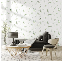 Obývací pokoj s květinovým vzorem na zdi, pohovkou, stolem, židlí a kobercem pro světlou a přátelskou atmosféru.