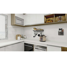 Světlá kuchyně s bílými skříňkami, kuchyňskými potřebami a spotřebiči