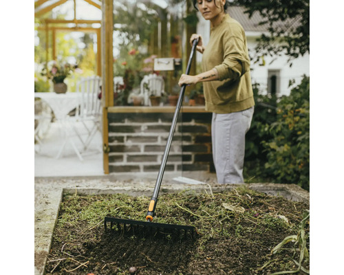 Žena hrábě zahradní záhon zahradními hráběmi