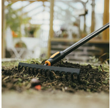 Zahradní hrábě používané na záhoně se zeminou.