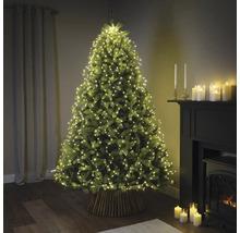 Ozdobený vánoční stromek se světelným řetězem v obývacím pokoji.