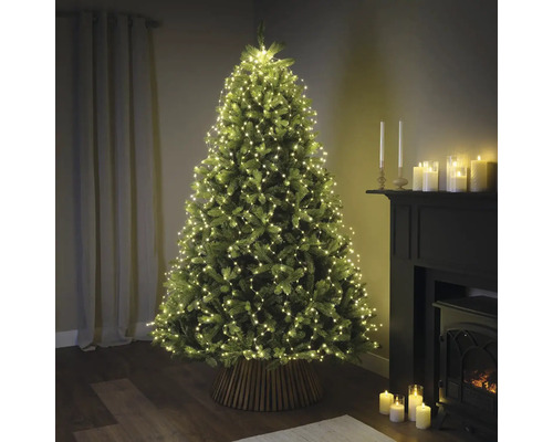 Ozdobený vánoční stromek se světelným řetězem v obývacím pokoji.