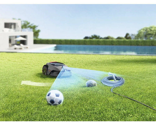 Robotická sekačka na trávníku s fotbalovým míčem, kamenem a zahradní hadicí