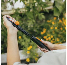 Dvě ruce spojují zavlažovací systém Fiskars.