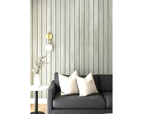 Obývací pokoj s šedou pohovkou, polštáři a tapetou se vzorem pruhů