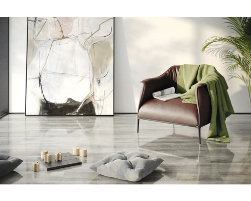 Obývací pokoj s křeslem, dekou, polštáři, abstraktním uměním a hrou piškvorky