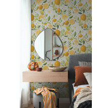 Ložnice s tapetou na stěně zdobenou citrony a květinovými motivy, doplněná zrcadlem, plovoucí policí a postelí.